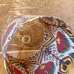 Zoom sur une lampe bohème ethnique avec abat-jour en soie ikat, tissé à la main en Ouzbékistan