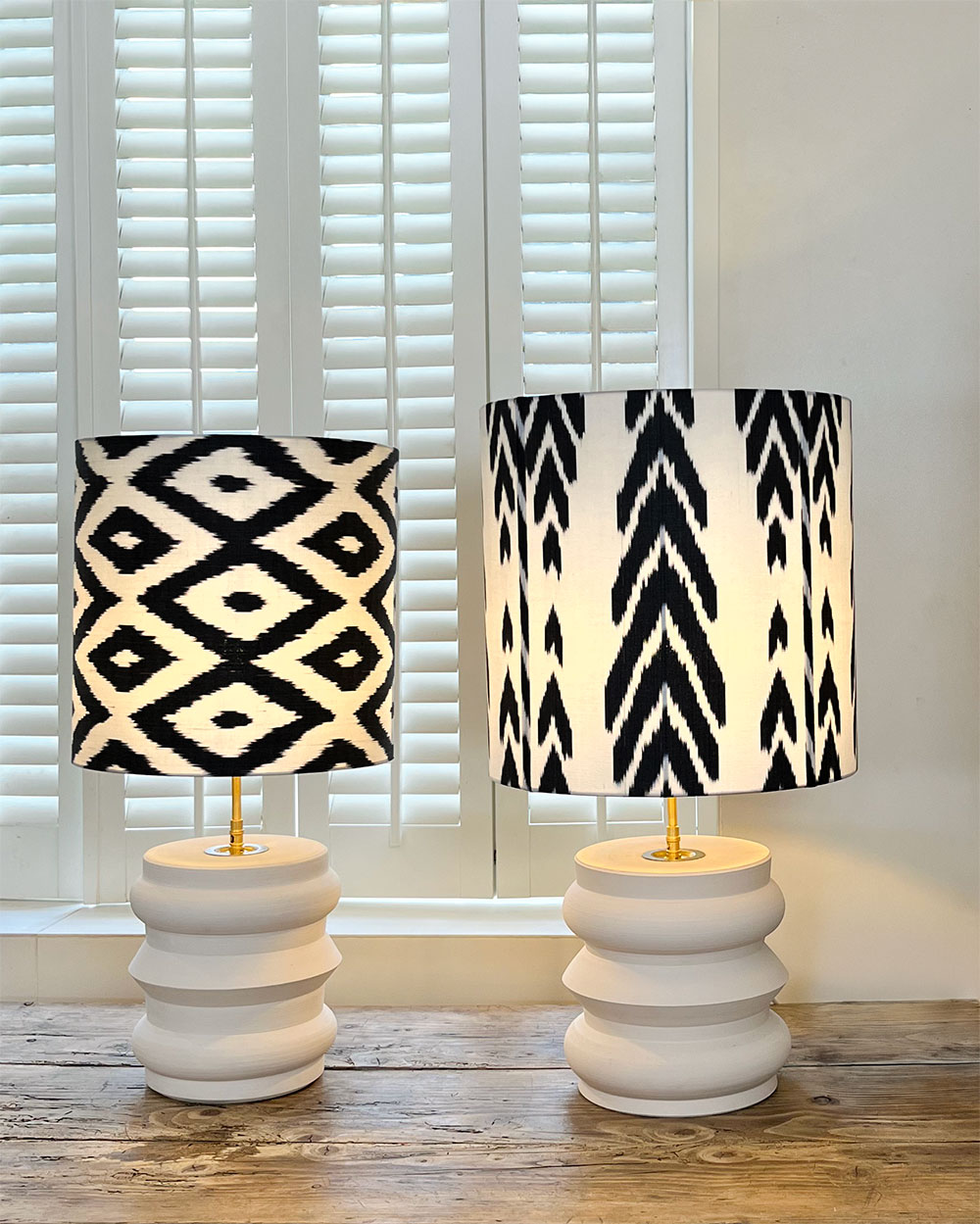 Lampe Noir IKAT pied blanc + lampe Éclat Nocturne côte à côte sur un buffet