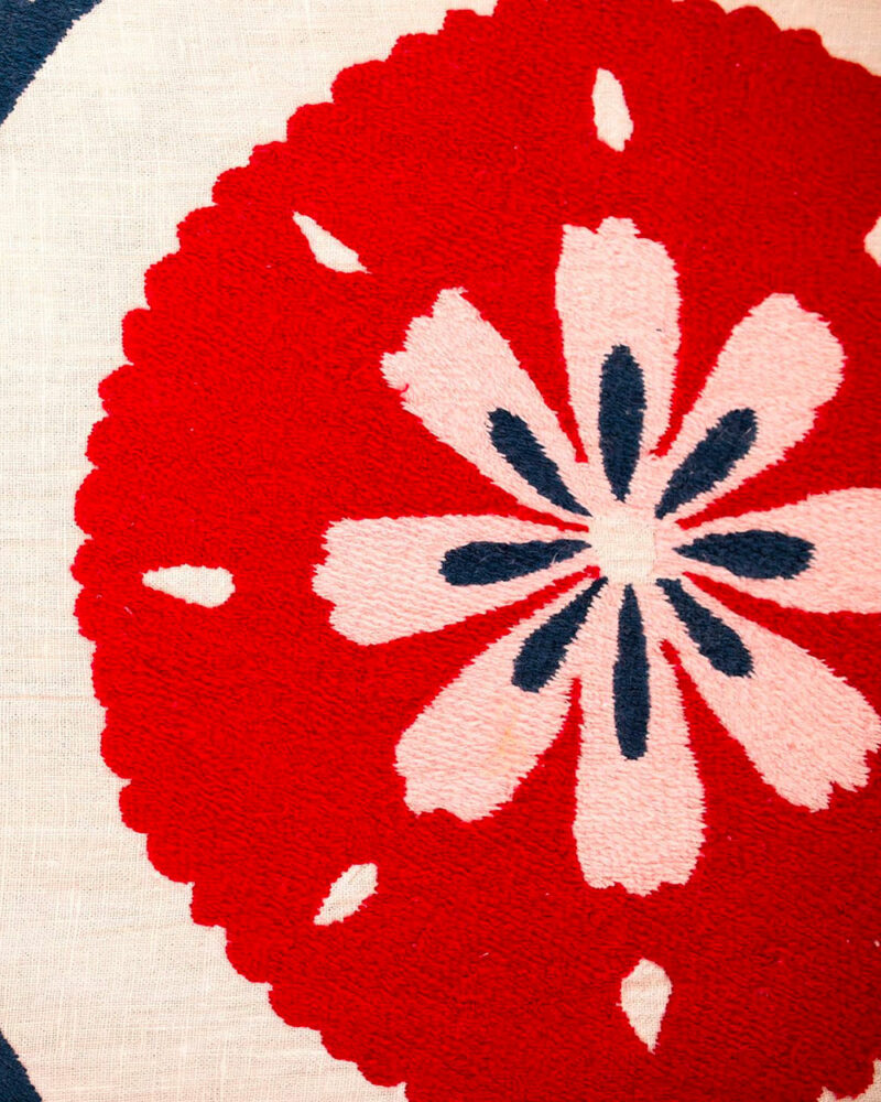 Gros plan sur les broderies colorées du plaid ANOR, cousues main par des artisanes en Ouzbékistan.