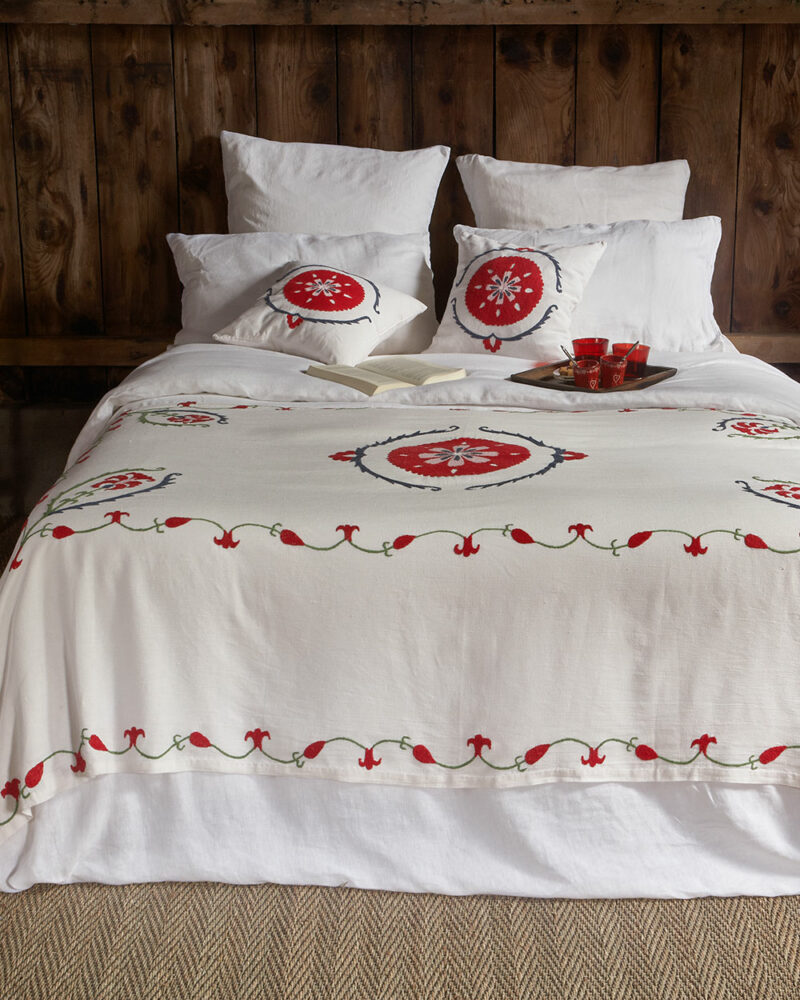 Plaid bohème chic ANOR en lin ivoire brodé main, pièce artisanale colorée pour une décoration élégante.