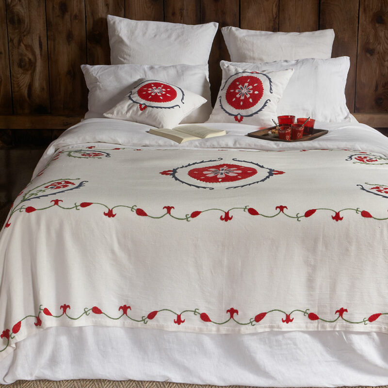 Plaid bohème chic ANOR en lin ivoire brodé main, pièce artisanale colorée pour une décoration élégante.