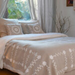 Plaid en lin brodé blanc SHAKLI dans une chambre lumineuse style campagne chic.