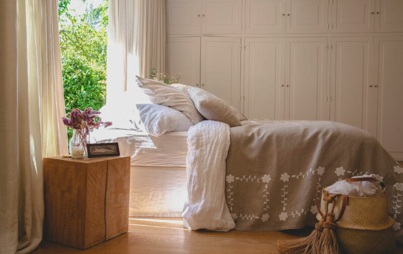 Plaid SHAKLI en lin beige brodé blanc sur un lit, décoration de chambre campagne chic élégante et intemporelle.