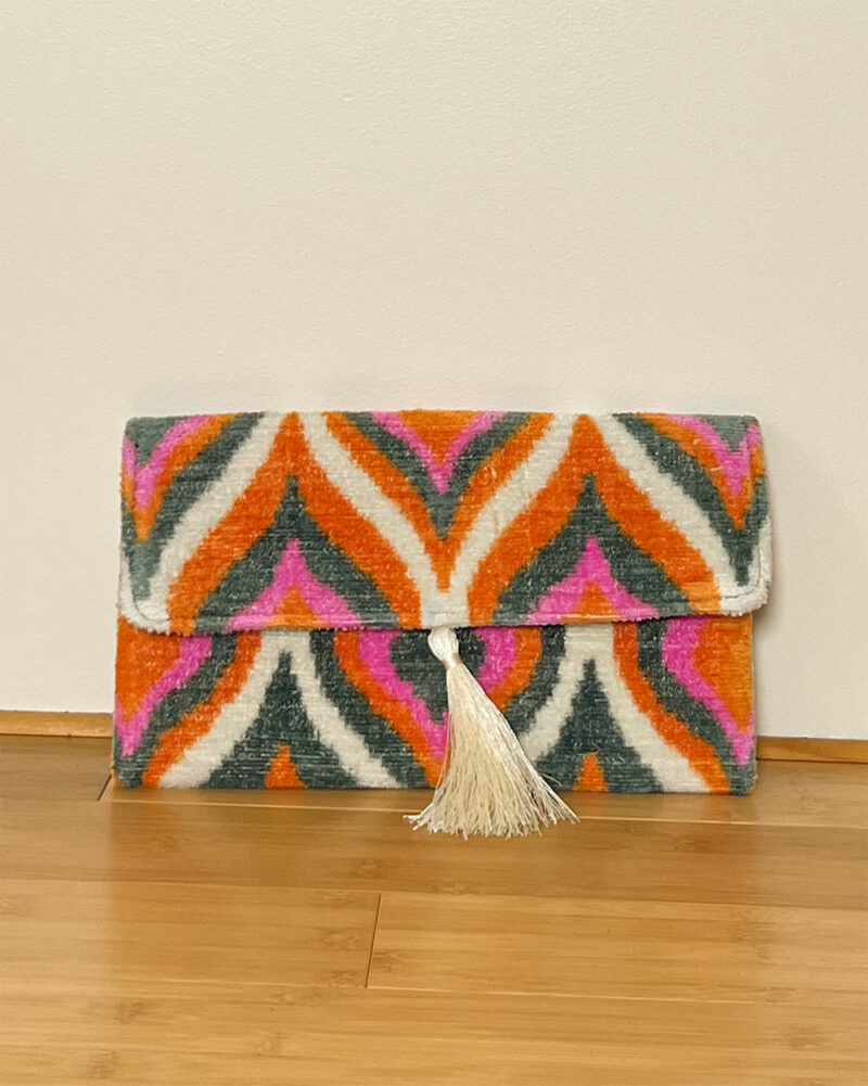 Pochette en velours BOHO rose orangé sur fond neutre