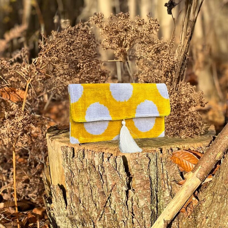 Pochette en velours NIFTY posée sur des feuilles en forêt à l’automne