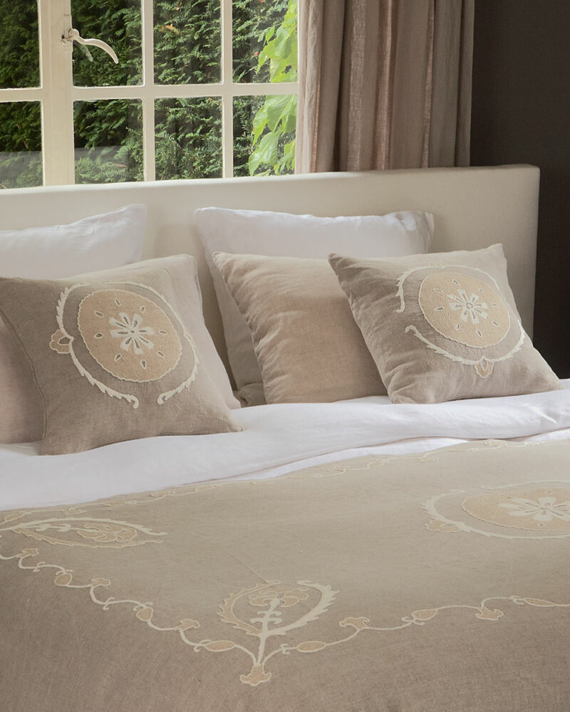 Coussins SITORA en lin brodé naturel disposés sur un lit en lin – ensemble raffiné et harmonieux de la collection C & the flowers