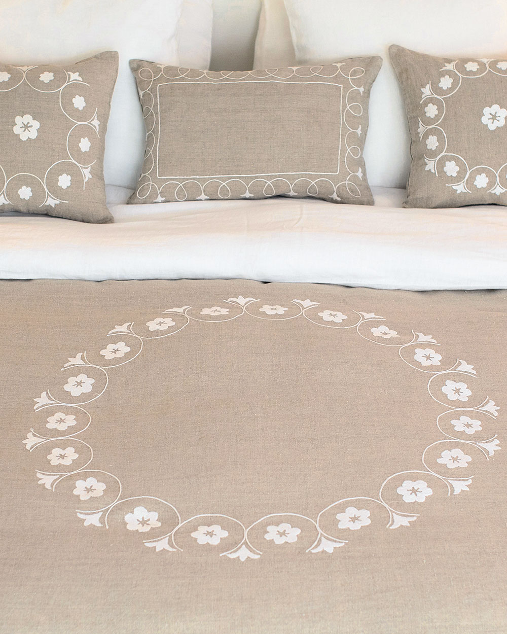 Couvre-lit brodé en lin naturel Shamya sur un lit, broderie blanche