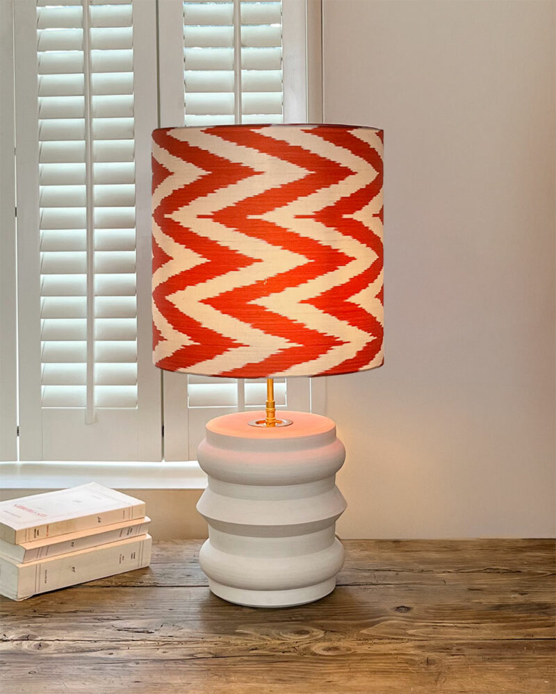 Lampe orange Capucine posée dans un intérieur chaleureux.