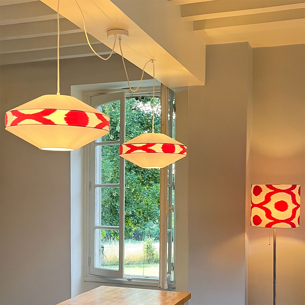 Deux suspensions luminaires rouges et blanches au-dessus d’un îlot de cuisine